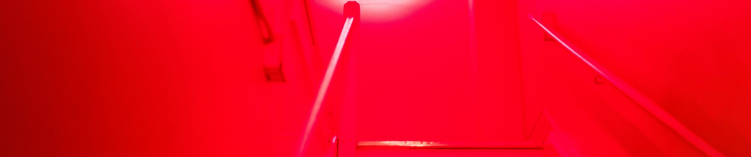 Bilde av et neon-smilefjes i et rødt mystisk rom